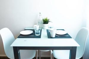 a black and white table with white plates and glasses at Apartamento Edificio Callao in Ferrol