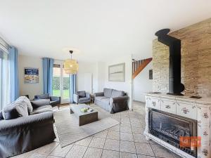 a living room with a fireplace and a living room with couches at La marinière in Audinghen