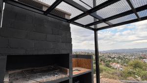 a black brick fireplace with a view of a city at Amanecer Serrano Carlos Paz in Villa Carlos Paz