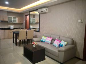 a living room with a couch and a dining room at Thamrin Residence City Home in Jakarta