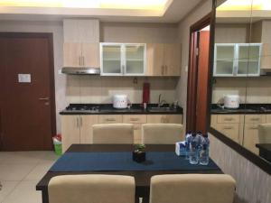 a kitchen with a table and chairs in a room at Thamrin Residence City Home in Jakarta +1 photo