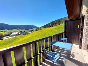 a blue bench on a balcony with a view of a hill at Appartement cosy à Méaudre - 2 chambres, 5 pers, parking, lave-linge - FR-1-737-39 in Méaudre