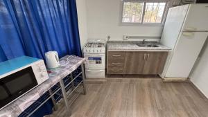 a small kitchen with a refrigerator and a sink at Amanecer Serrano Carlos Paz in Villa Carlos Paz