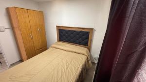 a small bedroom with a bed and a cabinet at Amanecer Serrano Carlos Paz in Villa Carlos Paz