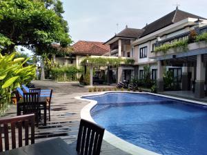 a swimming pool in front of a house at Hotel Dhyana Pura in Kapal
