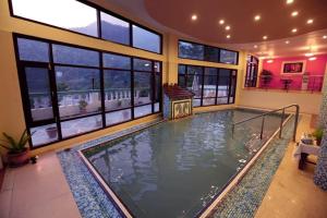 a large indoor swimming pool in a house at Hotel Hot Spring & Health Care in Tattapani