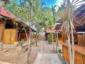 a courtyard of a house with palm trees at Bamboo Lombok Homestay in Kuta Lombok