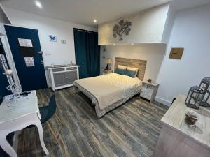 sypialnia z łóżkiem i biurkiem w obiekcie Chambres d'hôtes à la forge du Coglais w mieście La Selle-en-Coglès