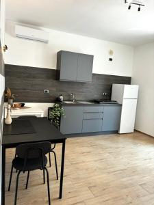 a kitchen with a black table and a white refrigerator at Bella Blue B&B in Bisceglie