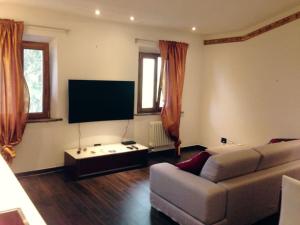 a living room with a couch and a flat screen tv at Fashion House Tuscany ARTIMINO in Artimino