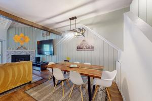 a dining room with a wooden table and white chairs at Chamonix 20 in Mammoth Lakes