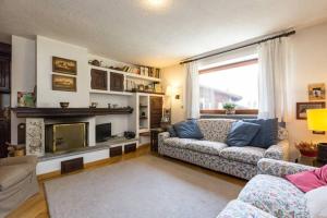 a living room with a couch and a fireplace at Chalet di Charme a Courmayeur in Courmayeur