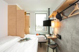 ein Schlafzimmer mit zwei Betten und einem Schreibtisch und einem Fenster in der Unterkunft ibis budget Gent Centrum Dampoort in Gent + 80 Fotos