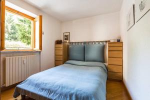 庫爾馬耶烏爾的住宿－Chalet di Charme a Courmayeur，一间卧室设有蓝色的床和窗户。