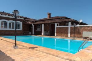 a swimming pool in front of a house at Pousada Casa da Vó Dita in Ouro Fino