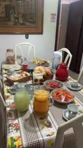 a table with food and other foods on it at Pousada Casa da Vó Dita in Ouro Fino