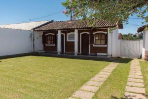 a house with a grass yard in front of it at Pousada Casa da Vó Dita in Ouro Fino