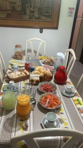 a table with food and drinks and food on it at Pousada Casa da Vó Dita in Ouro Fino