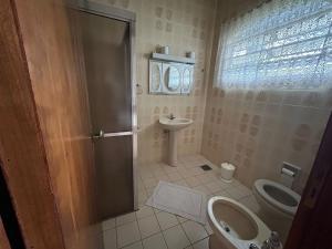 a bathroom with a toilet and a sink at Pousada Casa da Vó Dita in Ouro Fino