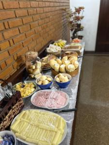 a buffet with many different types of food on a table at Pousada Casa da Vó Dita in Ouro Fino