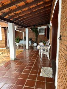 an outdoor patio with a table and a brick wall at Pousada Casa da Vó Dita in Ouro Fino