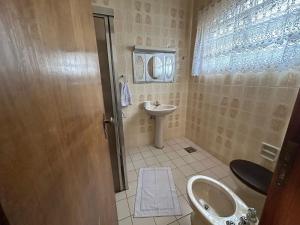 a small bathroom with a sink and a toilet at Pousada Casa da Vó Dita in Ouro Fino
