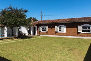a brick house with a yard in front of it at Pousada Casa da Vó Dita in Ouro Fino