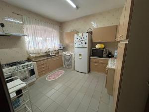a kitchen with a refrigerator and a microwave at Pousada Casa da Vó Dita in Ouro Fino