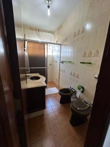 a bathroom with two toilets and a sink at Pousada Casa da Vó Dita in Ouro Fino