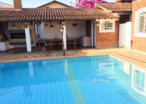 a swimming pool in front of a house at Pousada Casa da Vó Dita in Ouro Fino