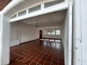 an empty garage with a brick floor and white walls at Pousada Casa da Vó Dita in Ouro Fino