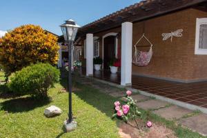 a house with a light pole in the yard at Pousada Casa da Vó Dita in Ouro Fino