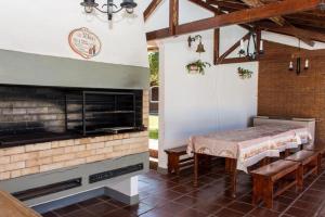a patio with a table and a fireplace at Pousada Casa da Vó Dita in Ouro Fino
