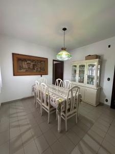 a dining room with a white table and chairs at Pousada Casa da Vó Dita in Ouro Fino