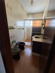 a small bathroom with a toilet and a sink at Pousada Casa da Vó Dita in Ouro Fino