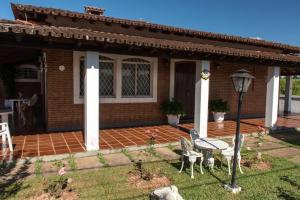 a house with a table and chairs in the yard at Pousada Casa da Vó Dita in Ouro Fino