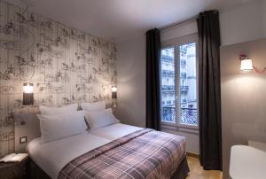 a bedroom with a bed and a window at Le Mireille in Paris