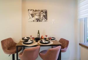 a dining room table with chairs and a bottle of wine at Aquamarine - Beach Flat in Itea +36 photos