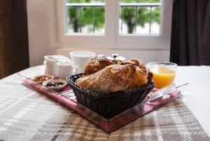 a basket of bread and orange juice on a table at Le Mireille in Paris