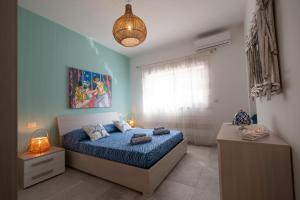 a bedroom with a bed and a pendant light at BAIA DELLE AGAVI in Taranto