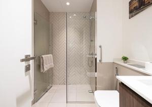 une salle de bain avec une douche avec une porte vitrée dans l'établissement Ultra Luxury Apartment by Blue Cloud Holidays, à Ḩiz̧āyib az Zānah