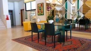 a dining room with a glass table and chairs on a rug at Hotel Cristallo in Giulianova