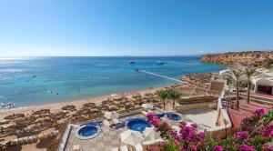 Una vista de una playa con sombrillas y el océano. en Sentido Reef Oasis Aqua Park Resort, en Sharm El Sheikh