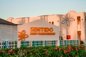 a building with a sign for sentido next to a fence at Sentido Reef Oasis Aqua Park Resort in Sharm El Sheikh