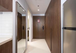 a hallway with wooden cabinets and a refrigerator at Apartment at Al Zahia - The Pearl in Ḩiz̧āyib az Zānah