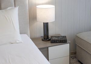 a lamp on a night stand next to a bed at Apartment at Al Zahia - The Pearl in Ḩiz̧āyib az Zānah