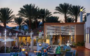 a restaurant with blue chairs and palm trees at Sentido Reef Oasis Aqua Park Resort in Sharm El Sheikh