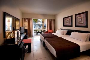 a hotel room with two beds and a television at Reef Oasis Beach Aqua Park Resort in Sharm El Sheikh
