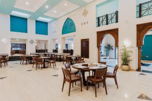 a dining room with tables and chairs in a building at Reef Oasis Beach Aqua Park Resort in Sharm El Sheikh