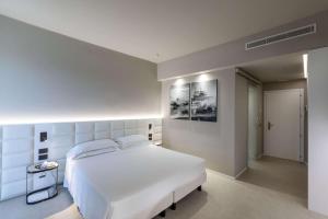 a white bedroom with a large white bed in it at Hotel Cristallo in Giulianova